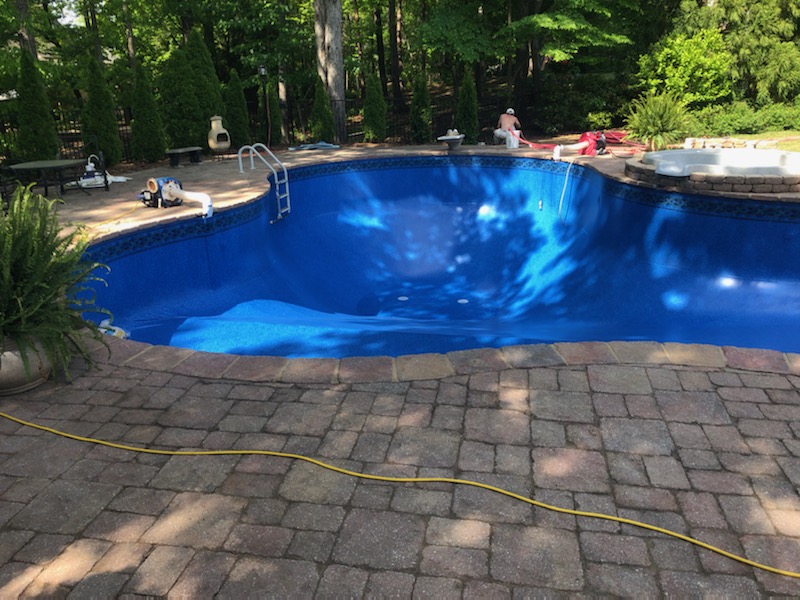 Beautiful freeform pool with fresh blue vinyl liner installation