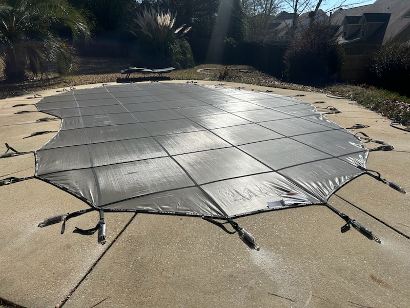 Pool safety cover professionally installed over rectangular pool